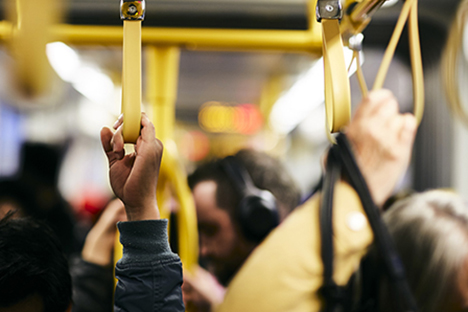 Featured news image shows tram passengers holding onto hand loops.