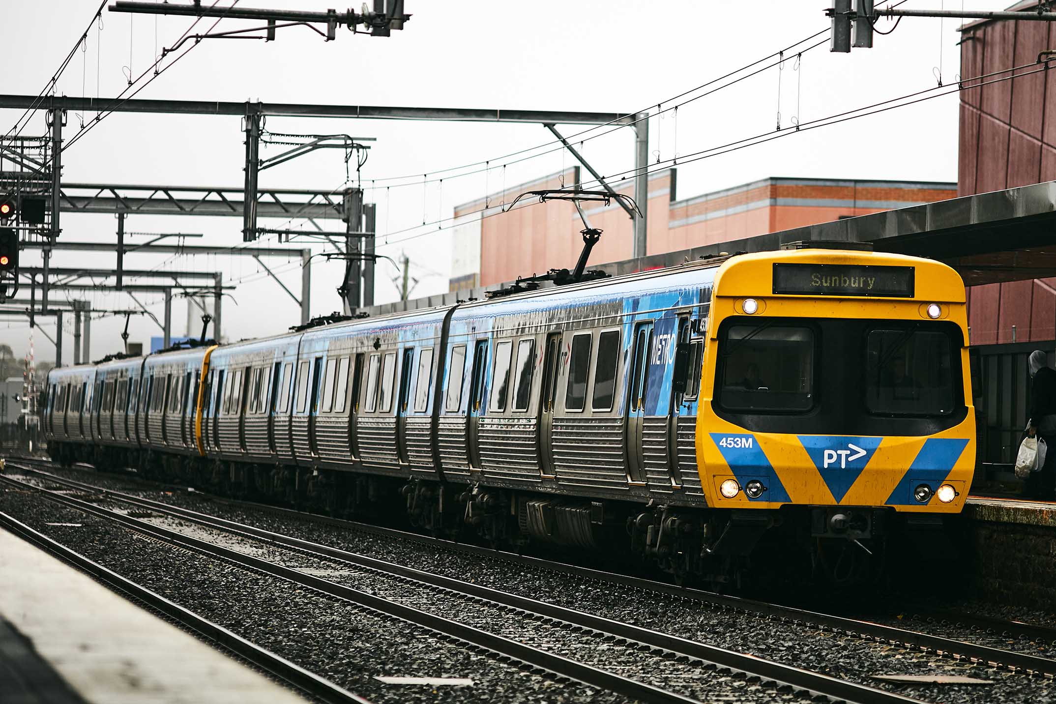 Image shows Metro Train waiting at a station platform.